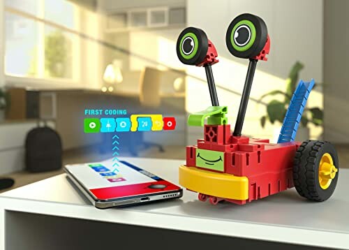 Speelgoedrobot met programmeerapp op telefoon