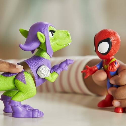 Twee speelgoedfiguren, een dinosaurus en Spiderman