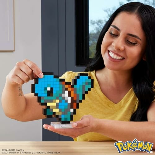 Vrouw houdt pixelkunst Pokémon-speeltje vast.