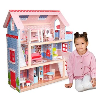 Kind naast houten poppenhuis met meubels